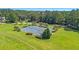 Aerial view of community tennis courts with green and blue playing surfaces, surrounded by beautiful trees and well-manicured lawns at 5358 Birdie Ln, Hollywood, SC 29449