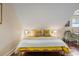 Bedroom with white and yellow bedding, dark wood floors and an abundance of natural light at 55 Ashley Ave # 19, Charleston, SC 29401