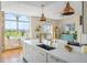 Bright, modern kitchen with a large island, white cabinets, gold hardware, and copper pendant lights at 55 Ashley Ave # 19, Charleston, SC 29401