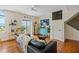 Bright living room featuring hardwood floors, a comfortable couch, and a view of the staircase at 55 Ashley Ave # 19, Charleston, SC 29401