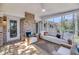 Cozy sunroom featuring an off-white sofa, brick fireplace, and wooden floors at 6 Allison Ct, Charleston, SC 29407
