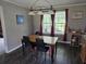 Bright dining room featuring a wooden table with black chairs, red curtains, and ample natural light at 60 Caboose Ct, Cottageville, SC 29435