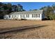 Single-story home featuring black shutters, a welcoming front porch, and a small carport at 60 Caboose Ct, Cottageville, SC 29435