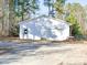Detached single garage featuring white siding, a garage door, and an entry door at 60 Caboose Ct, Cottageville, SC 29435