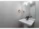 Stylish powder room with a pedestal sink, black hardware, and a well-lit mirror at 6273 Ballpark Rd Rd, Hollywood, SC 29449