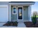 Inviting front door of a modern home featuring vertical siding, painted address numbers, and manicured landscaping at 6273 Ballpark Rd Rd, Hollywood, SC 29449