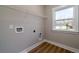 Bright laundry room with a window, laminate floors, and hookups for washer and dryer at 6273 Ballpark Rd Rd, Hollywood, SC 29449