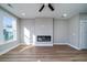 Bright living room with contemporary fireplace, ceiling fan, wood-look flooring, and large window for natural light at 6273 Ballpark Rd Rd, Hollywood, SC 29449