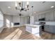 Open-concept living space features wood-look flooring, fireplace, modern chandelier, and gray kitchen cabinets at 6273 Ballpark Rd Rd, Hollywood, SC 29449