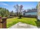 Large backyard showcasing a well-maintained lawn, wooden fence, and serene pond view at 644 Stoneboro Ct, Charleston, SC 29412