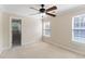 A bright bedroom with neutral walls, carpet, ceiling fan, and a view through the open door at 644 Stoneboro Ct, Charleston, SC 29412
