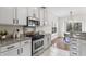 Galley kitchen features stainless appliances, granite countertops, stylish cabinets, and an adjacent dining area at 644 Stoneboro Ct, Charleston, SC 29412