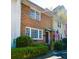 Charming brick townhouse with well-maintained landscaping, an American flag, and large windows at 7 Doughty St # C, Charleston, SC 29403
