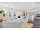 Bright and open living room with a comfortable white sofa, ample seating, and a seamless view into the modern kitchen at 796 Clay Field Trl, Summerville, SC 29485