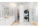 Modern bathroom featuring a double vanity and conveniently stacked washer and dryer in an alcove at 800 Clay Field Trl, Summerville, SC 29485