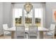 Bright dining room featuring an elegant chandelier, large windows, and a stylish table setting at 800 Clay Field Trl, Summerville, SC 29485