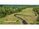 Community dock with path leading from land to the water surrounded by lush vegetation at 8661 Refuge Point Cir, North Charleston, SC 29420