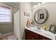 Bright bathroom featuring a marble-top vanity with a decorative mirror and a shower with white curtain at 8661 Refuge Point Cir, North Charleston, SC 29420