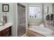 Bathroom featuring dual vanities, soaking tub and separate glass shower at 8661 Refuge Point Cir, North Charleston, SC 29420