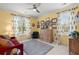 Comfortable room with yellow walls, blue drapes, plush gray rug, and a red sofa beneath a ceiling fan at 8661 Refuge Point Cir, North Charleston, SC 29420