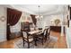 Formal dining room features chandelier, hardwood floors, and decorative curtains at 8661 Refuge Point Cir, North Charleston, SC 29420
