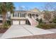 Charming two-story home with a brick foundation, wide driveway, and inviting front porch, perfect for Lowcountry living at 8661 Refuge Point Cir, North Charleston, SC 29420