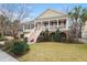 Inviting Lowcountry-style home featuring a spacious porch, landscaped yard, and charming architectural details at 8661 Refuge Point Cir, North Charleston, SC 29420
