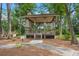 Community gazebo for residents only featuring a roof, open sides, and stairs, surrounded by lush trees and greenery at 8661 Refuge Point Cir, North Charleston, SC 29420
