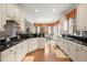 Charming kitchen with white cabinets, granite countertops, hardwood floors, and a cozy breakfast nook with bay window at 8661 Refuge Point Cir, North Charleston, SC 29420