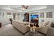 Inviting living room features neutral couches, french doors, a ceiling fan, and views of the backyard at 8661 Refuge Point Cir, North Charleston, SC 29420