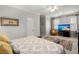 Spacious main bedroom featuring an elegant ceiling fan, a comfortable chair, and a television for relaxing evenings at 8661 Refuge Point Cir, North Charleston, SC 29420