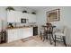 Stylish wet bar with white cabinetry, a sink, a mini fridge, and a cozy dining area with seating at 8661 Refuge Point Cir, North Charleston, SC 29420