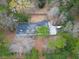 Aerial view of a home nestled among mature trees, with a large yard, driveway, and fencing at 9030 Ethel Rd, North Charleston, SC 29406
