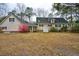 A large backyard with mature trees, a lush, flowering shrub, and a well-maintained home exterior at 9030 Ethel Rd, North Charleston, SC 29406