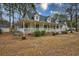 Lovely home with a cozy porch and a garage, framed by lush landscaping at 9030 Ethel Rd, North Charleston, SC 29406