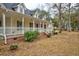 Beautiful home featuring a long, inviting front porch and mature landscaping at 9030 Ethel Rd, North Charleston, SC 29406