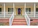 Inviting front porch with brick stairs and white railings provides a cozy entryway at 9030 Ethel Rd, North Charleston, SC 29406