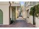 Brick-paved alleyway between buildings with colorful shutters and lush greenery at 92 Bogard St, Charleston, SC 29403