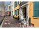 View of the yellow house entrance alongside brick sidewalk and other houses, showing community charm at 92 Bogard St, Charleston, SC 29403
