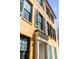 A sunny, low angle view of a yellow building, showcasing architectural features like many windows and green shutters at 92 Bogard St, Charleston, SC 29403