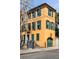 A sunny three-story home with green shutters and an attached garage door, located in a charming neighborhood at 92 Bogard St, Charleston, SC 29403