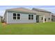 Pale blue home with siding, gray roof, green grass, and white trim around windows at 1036 Forrest Creek Dr, Summerville, SC 29483