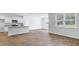 Living room with wood-look floors adjacent to a kitchen featuring an island and natural light at 1036 Forrest Creek Dr, Summerville, SC 29483