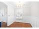 Bright dining room with modern lighting, wainscoting, wood floors, and plantation shutters at 104 Broadmarsh Ct, North Charleston, SC 29418