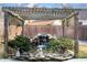 Backyard features a tranquil waterfall pond under a wooden pergola with mature landscaping and decorative garden statues at 104 Broadmarsh Ct, North Charleston, SC 29418