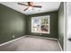 Bedroom with olive-colored walls, ceiling fan, carpet, and a window providing ample natural light at 105 Thousand Oaks Cir, Goose Creek, SC 29445