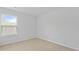 A bright bedroom offers neutral carpeting and a window with a view at 1054 Forrest Creek Dr, Summerville, SC 29483