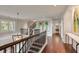 Upstairs landing with dark wood banister, chandelier, and hallway to a light-filled bathroom at 1126 Ocean Forest Lane, 1/8 Share, Seabrook Island, SC 29455