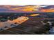 Sunset aerial view of a river with boat docks and waterfront homes nestled among lush trees at 12 Broughton Rd, Charleston, SC 29407