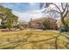 Spacious backyard with a large brick home, patio, seating, and manicured landscaping at 12 Broughton Rd, Charleston, SC 29407